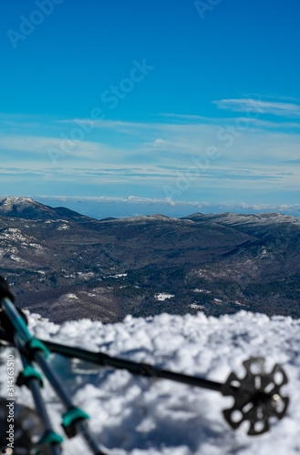 Ski poles sit at the edge of a mountain