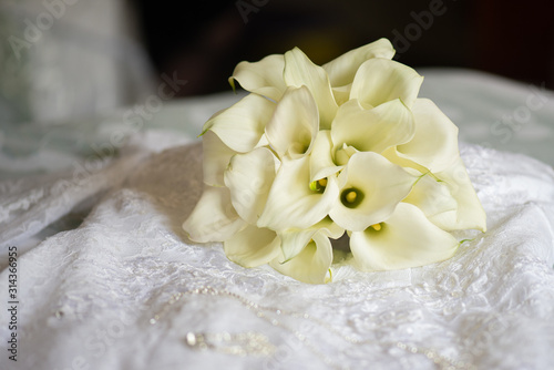 wedding rings on a bouquet of white roses