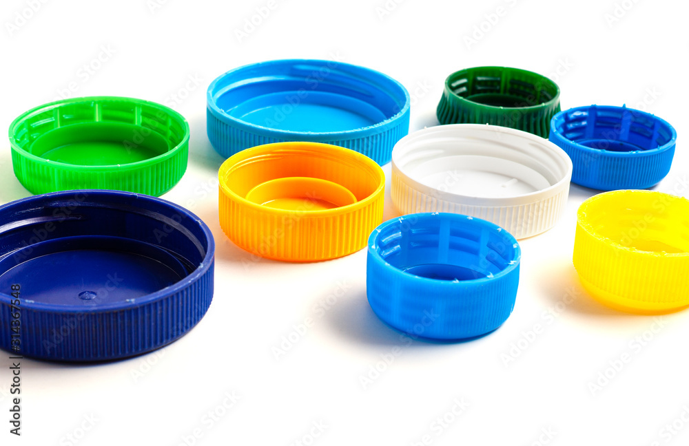 Colored plastic caps from bottles of water isolated on a white background. Close-up, top view. The pollution of Earth. Recycling used plastic - a solution to the problem of plastic contamination. Colored plastic caps from bottles of water isolated on a white background. Close-up, top view. The pollution of Earth. Recycling used plastic - a solution to the problem of plastic contamination.