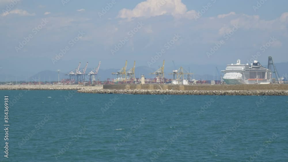 Cruise ships and cranes behind the breakwater in the port of Livorno, Italy Cruise ships and cranes behind the breakwater in the port of Livorno, Italy