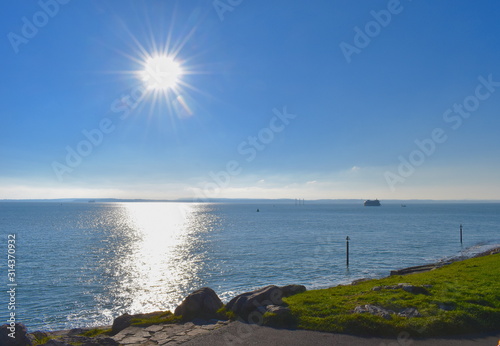 Sun shining brightly over Southsea beach. The beach lies mile south of Portsmouth city center with its shops, restaurants, bars. From the beach there are views across the Solent towards Isle of Wight photo