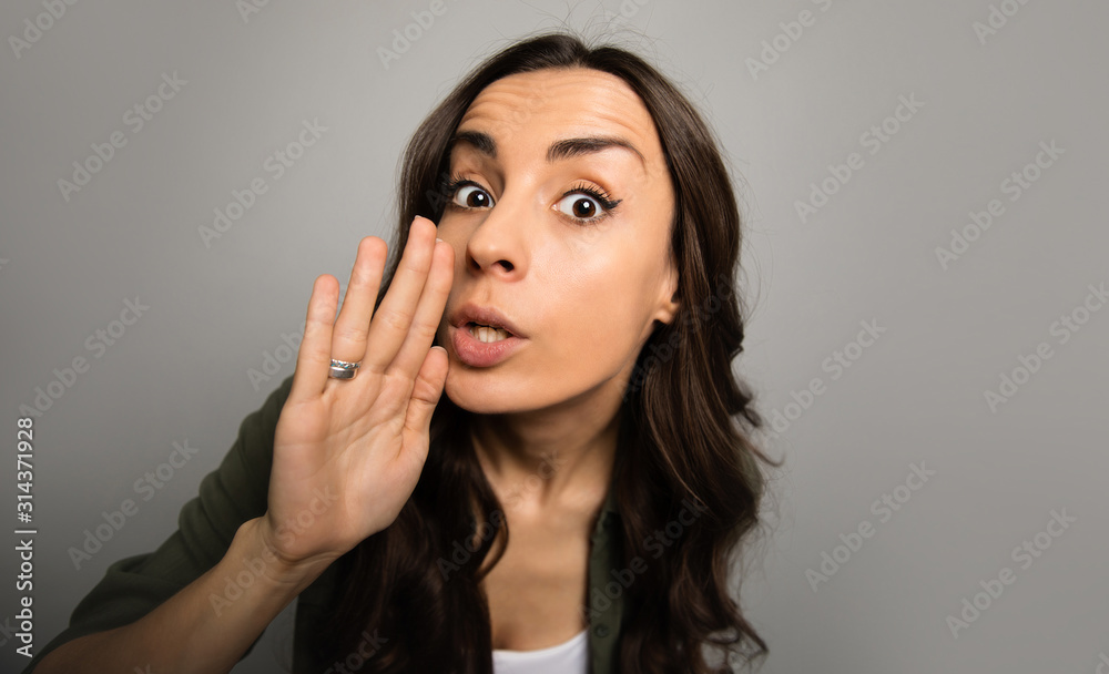 Let me tell you something. Close-up photo of a gorgeous girl with long chestnut hair, who whispers something to the camera. Let me tell you something. Close-up photo of a gorgeous girl with long chestnut hair, who whispers something to the camera.