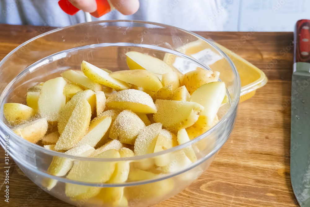 Raw potatoes cutting and peeling on table in a plate Raw potatoes cutting and peeling on table in a plate