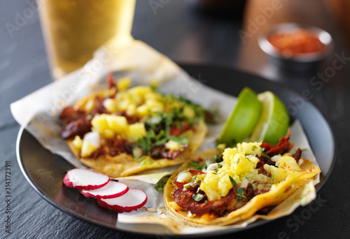 al pastor street tacos with pineapple, radish and beer photo