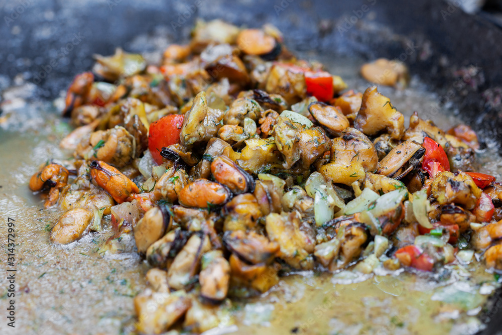 Mussels stewed with vegetables in a cauldron Mussels stewed with vegetables in a cauldron