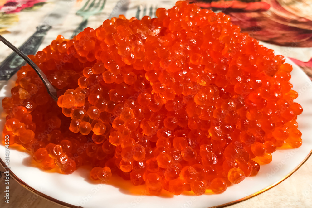 Red caviar on plate on the table. Salmon caviar. Dietary nutriti Red caviar on plate on the table. Salmon caviar. Dietary nutriti