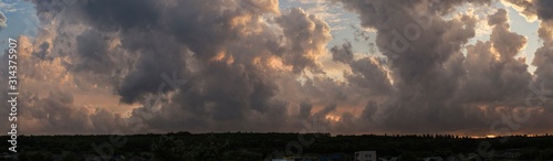 Fototapeta Ołowiane chmury burzowe zakrywały zachód słońca. Cumuliform cloudscape na niebieskim niebie. Teren w południowej Europie. Fantastyczne niebo na planecie Ziemia. Tragiczne ponure niebo ...