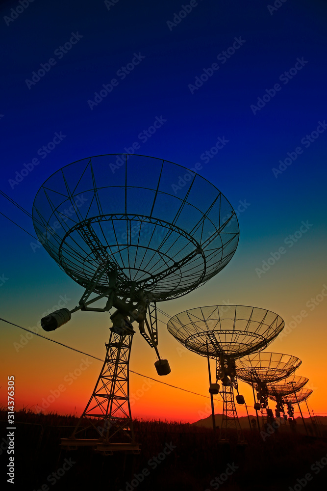 The silhouette of a radio telescope observatory