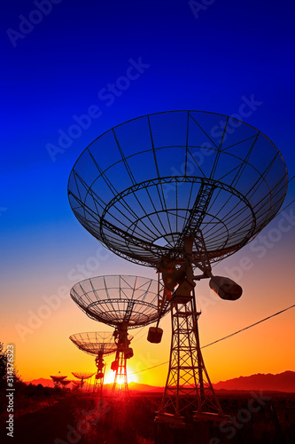 The silhouette of a radio telescope observatory