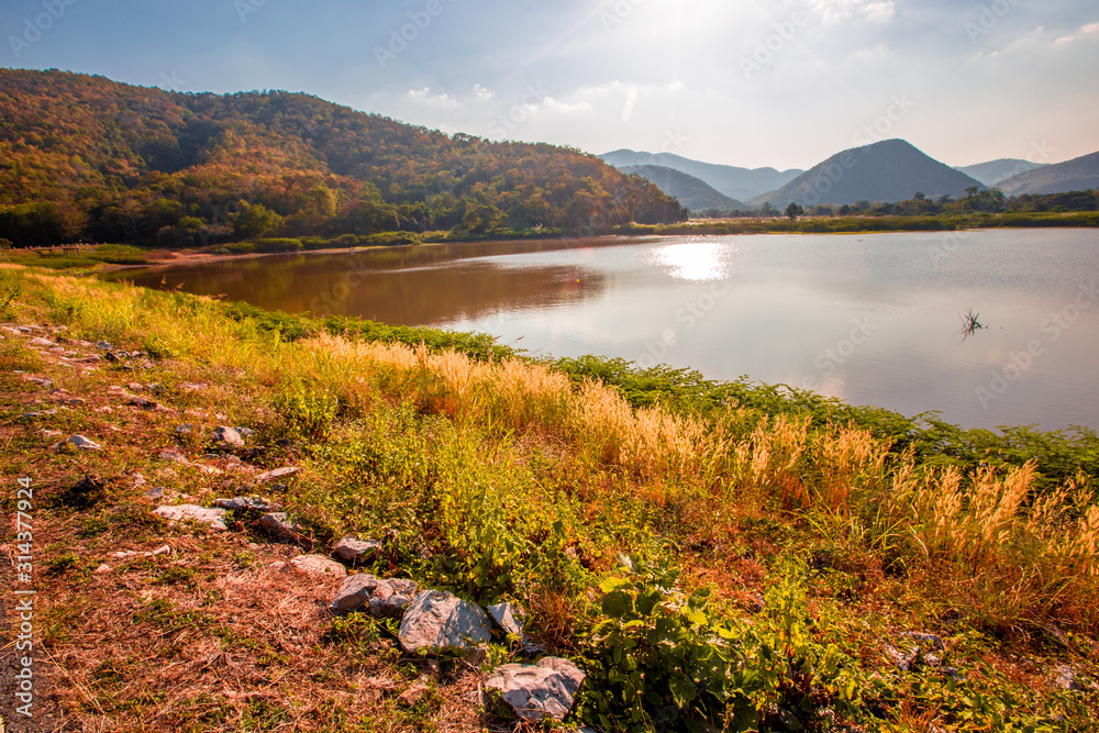 The blurred panoramic nature background of sunlight hitting the lake's surface, grass and wind blowing all the time along the large mountains, ecological beauty and fresh air. The blurred panoramic nature background of sunlight hitting the lake's surface, grass and wind blowing all the time along the large mountains, ecological beauty and fresh air.