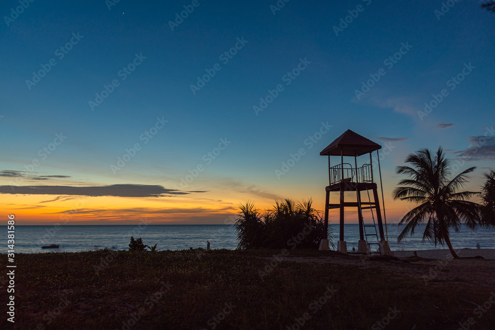 sunset at lifeguard tower in Karon beach. Karon beach is broad and long Sand and beautiful beach suitable for swimming and used as a training dive..Karon beach have many kind of water sports