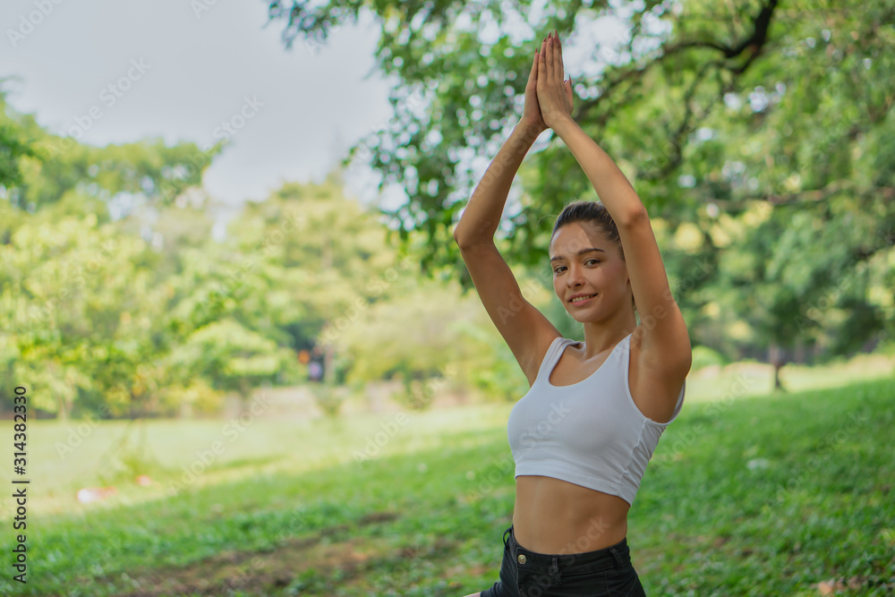 caucasian pretty woman having yoga in park