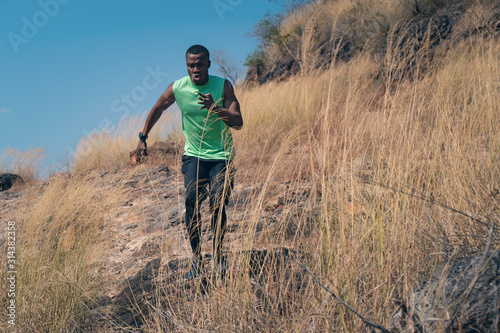 african american man having exerice with trail running at natural mountain