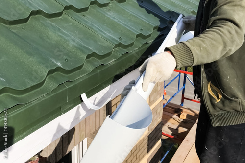 Workers work to assemble roof and drainage system.