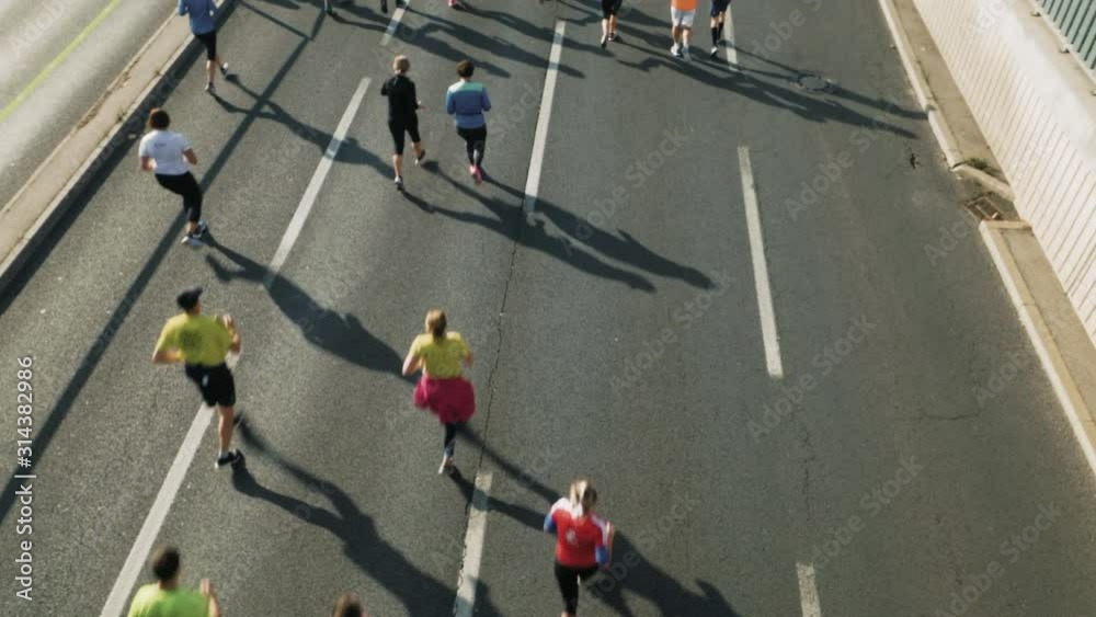 High angle from behind shot of marathon runners jogging