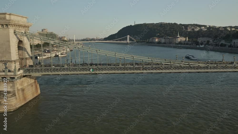 People walking on Széchenyi Chain Bridge in Budapest, Hungary during golden hour. People walking on Széchenyi Chain Bridge in Budapest, Hungary during golden hour.