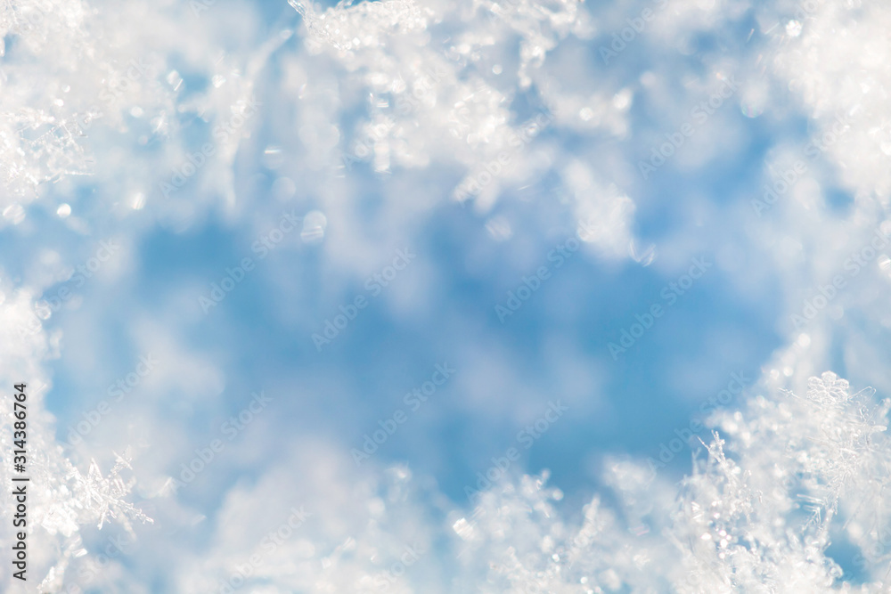 Background from crystal clear real snowflakes in blue and turquoise shades in macro with copy space for your text. Christmas and New Year winter background frame of natural ice snowflakes close-up. Background from crystal clear real snowflakes in blue and turquoise shades in macro with copy space for your text. Christmas and New Year winter background frame of natural ice snowflakes close-up.