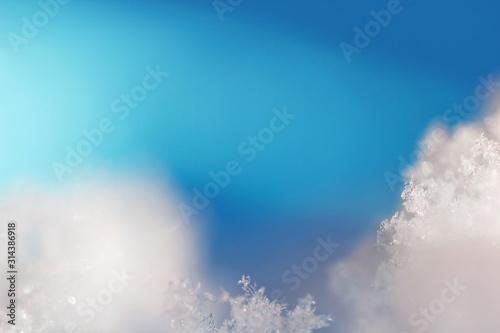 Background from real ice crystals in blue and turquoise shades in macro with copy space for your text. Christmas, New Year, winter frame with a border of natural ice crystals close-up.