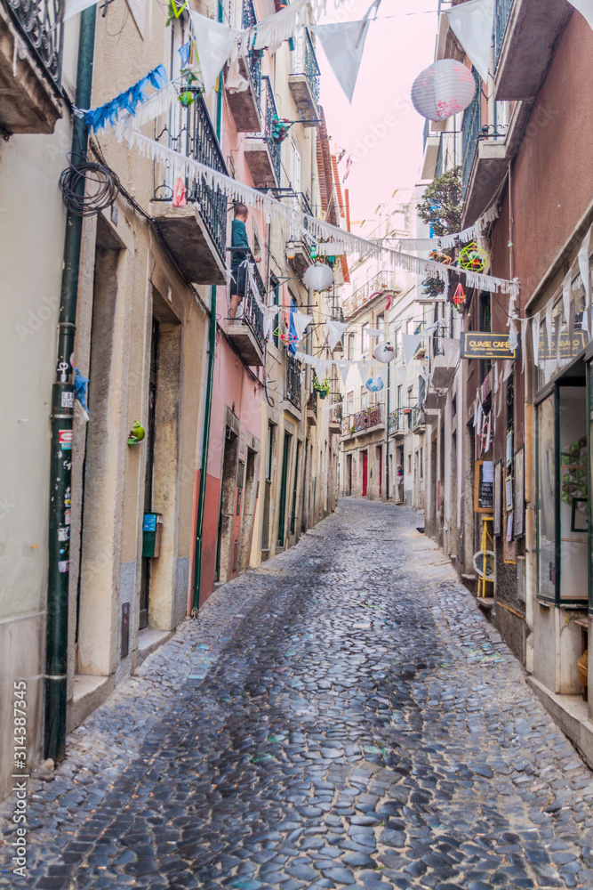 LISBON, PORTUGAL - OCTOBER 10, 2017: Narrow alley in Alfama neighborhood of Lisbon, Portugal