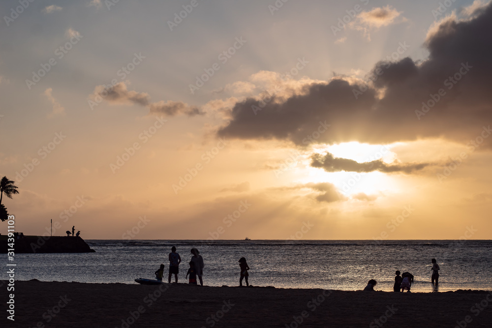 Sandy beach and ocean during sunset with clouds in the sky
