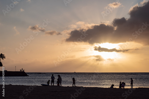 Sandy beach and ocean during sunset with clouds in the sky