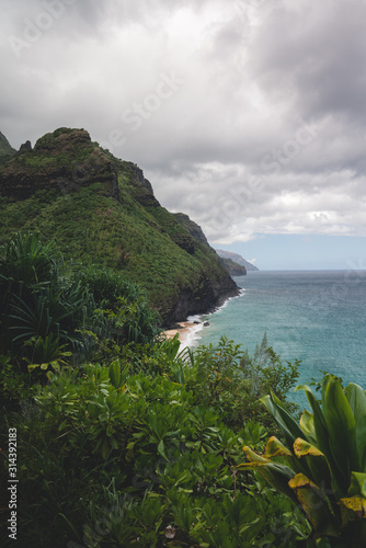 Seaside Coastline of Kauai, Hawaii during Cloudy Weather with blue water and green mountains for perfect getaway