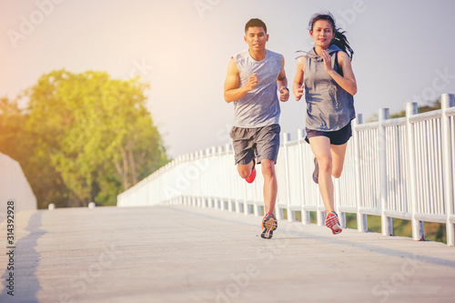 Young couples running sprinting on road. Fit runner fitness runner during outdoor workout
