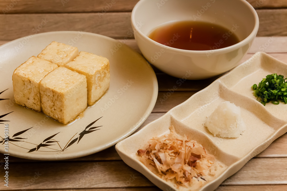 preparation of age dashi tofu. It is crispy deep fried tofu served with dashi sauce, green onion, grated radish and bonito flakes. preparation of age dashi tofu. It is crispy deep fried tofu served with dashi sauce, green onion, grated radish and bonito flakes.