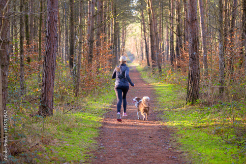 Woman out jogging in the morning with her dog © michaelheim
