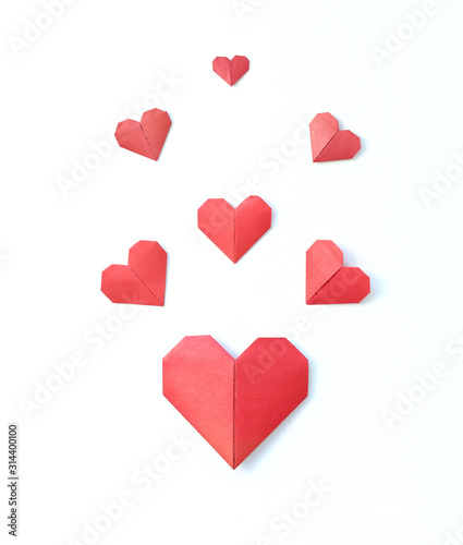 seven red hearts folded from origami paper on a white background. Love, valentines day concept