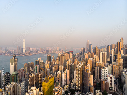 Aerial view of the sunset over the very crowded residential of Kennedy town and Sai Yin Pun in Hong Kong island with Kowloon in the background across the Victoria harbor