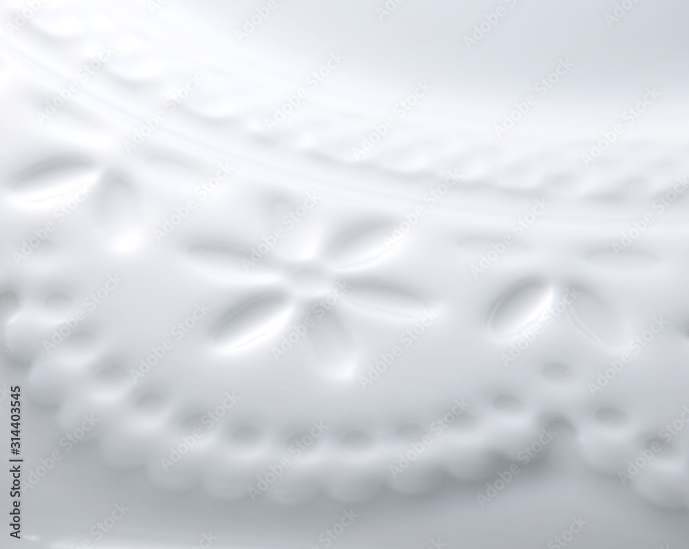 Closeup of white plate. white flower background. Closeup of white plate. white flower background.