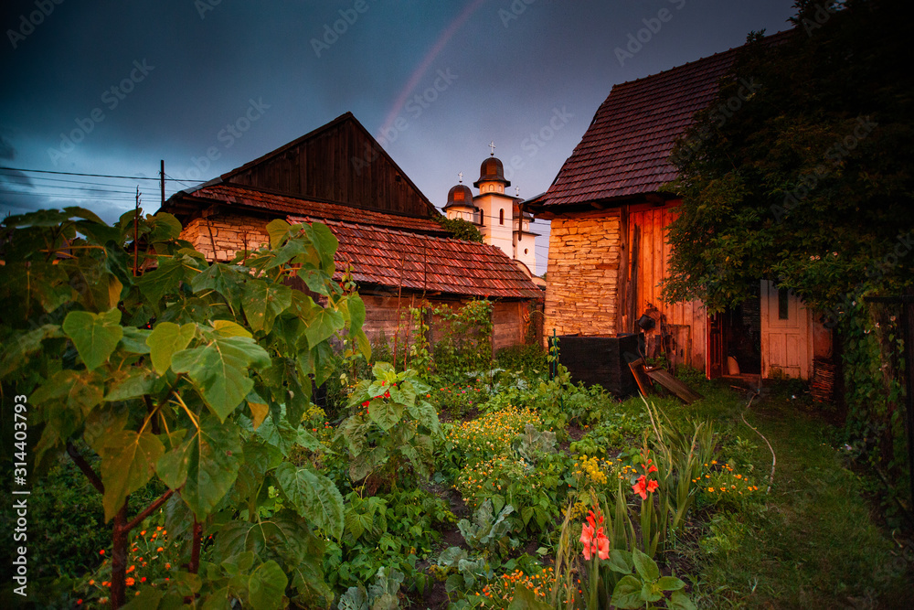 Naklejka premium rainbow over house and green garden