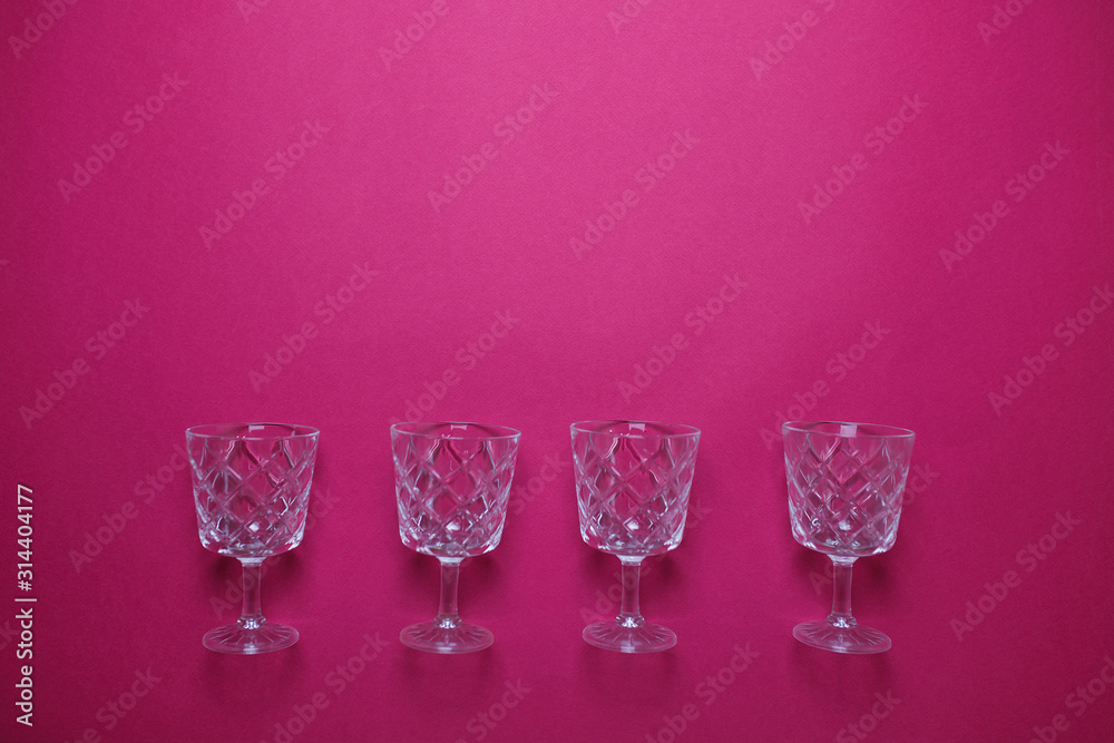 Four wine glasses on pink background with copy space. Four wine glasses on pink background with copy space.