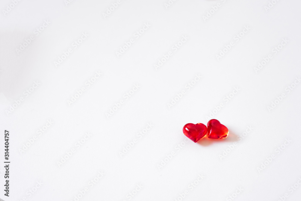Romantic Valentine's day card: two glass red hearts on a white background with copying space.