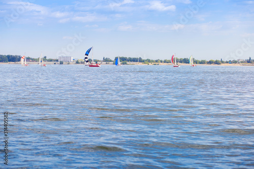 Sailing regatta is on the Volga River. Many yachts with sails on the water