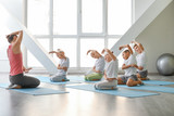 Little children practicing yoga with instructor in gym