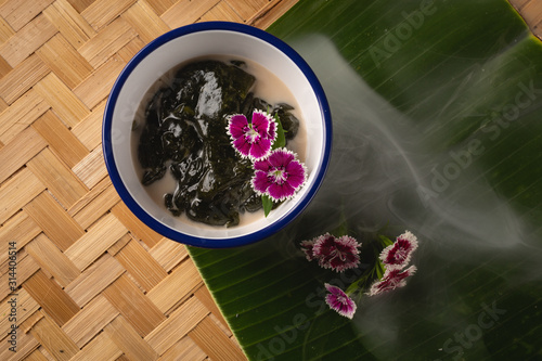 Thai dessert, Icevine, Pareira barva with coconut milk on wooden table, Top view photo