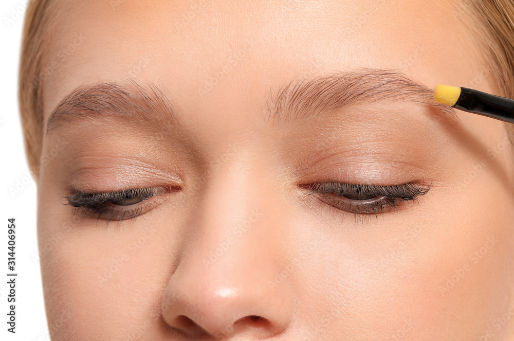 Young woman correcting shape of her eyebrows, closeup