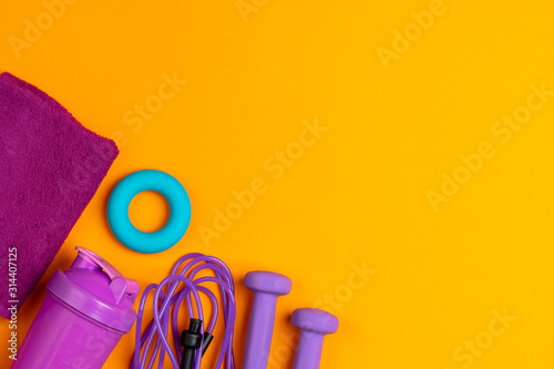 Assortment of sport equipment on yellow background, top view