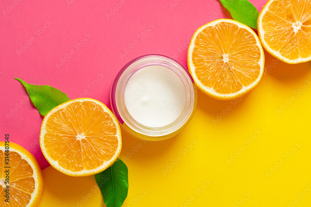 Cosmetic bottle with sliced citrus fruits on bright pink background Cosmetic bottle with sliced citrus fruits on bright pink background