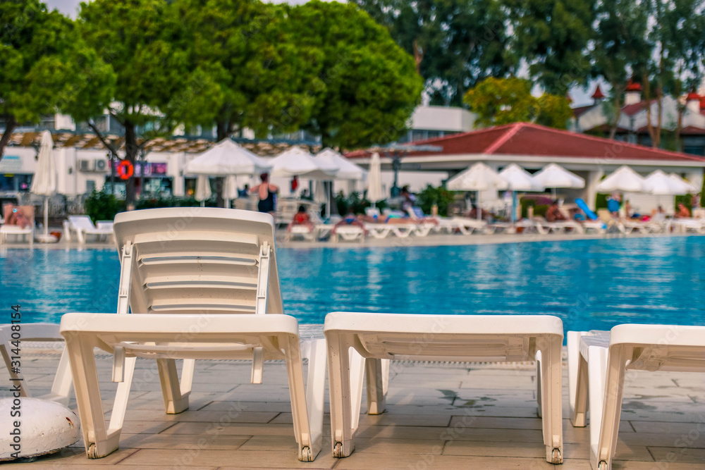White plank beds for suntan at hotel standing near the pool. White plank beds for suntan at hotel standing near the pool.