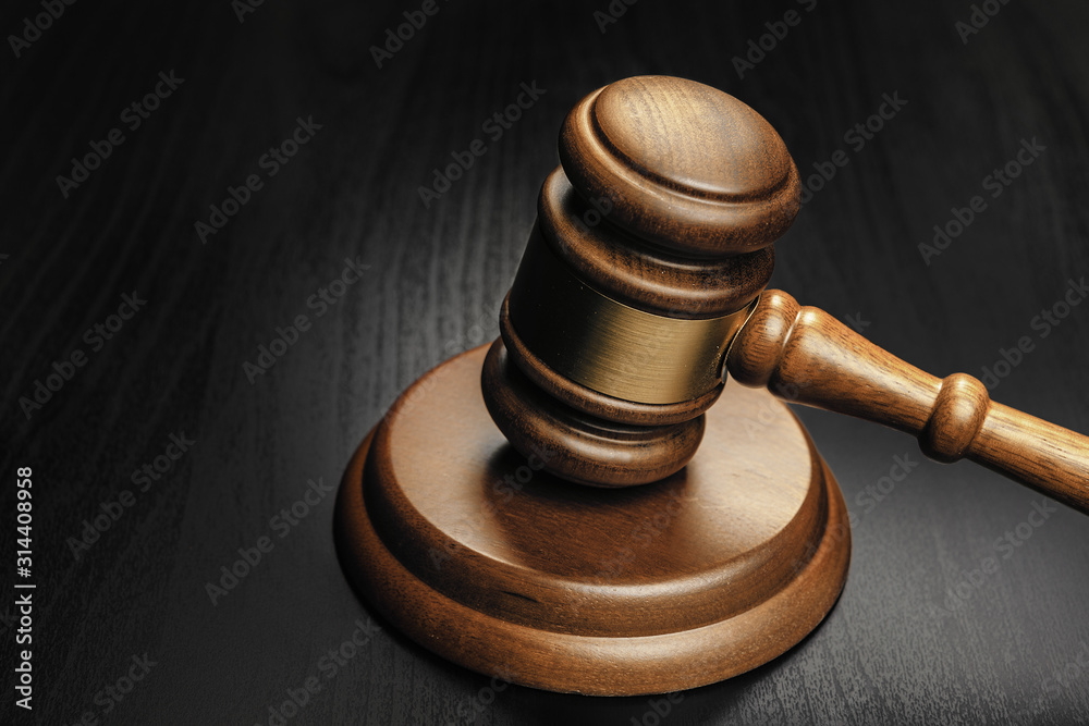 Wooden mallet on black wooden table close up