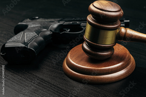 Foto gun and judge's gavel on the table
