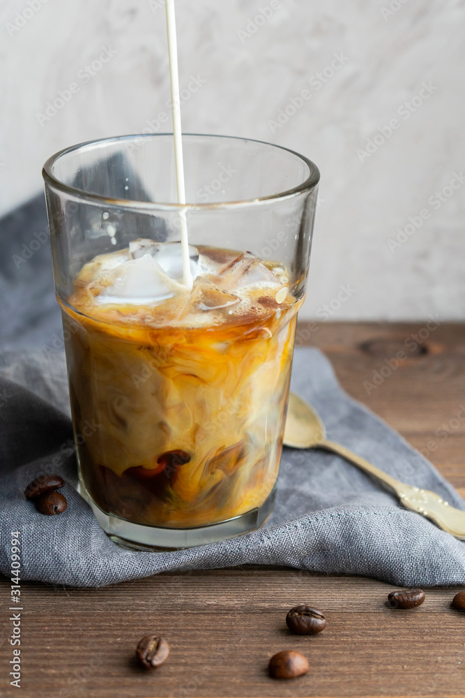 A stream of milk pours into coffee A stream of milk pours into coffee