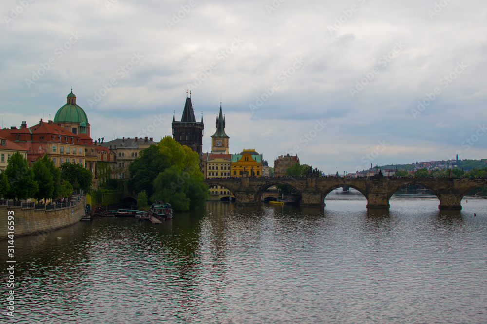 Vltava river flowing through Prague with Charles Bridge (Karlův most) and Old Town Bridge Tower (Staroměstská mostecká věž) at the background (Czech Republic)