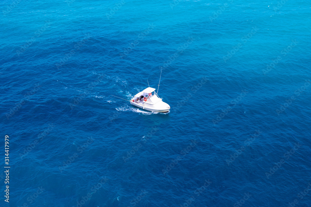 Motorized cruiser boat in blue sea of Caribbean island of Aruba.