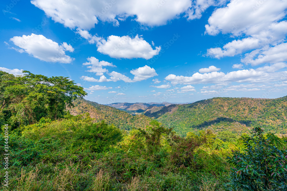 Obraz premium beautiful blue sky high peak mountains mist fog wildlife green forest at khao yai national park, Nakhon Ratchasima, Saraburi, Thailand guiding idea long weekend for backpacker camping campfire hiking