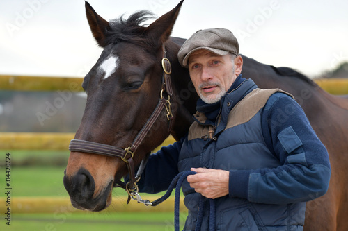 Portrait of horseman standing by horse