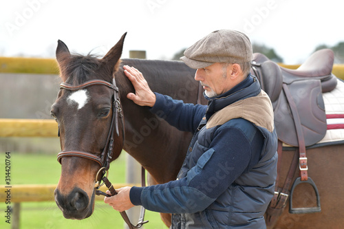 Portrait of horseman standing by horse